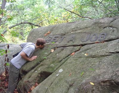 A large rock with "Get a Job" inscribed on it