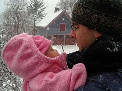 Photo of Tim Lindgren holding infant with snowy background
