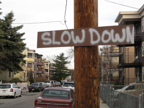 Slow Down spraypainted on a DIY sign