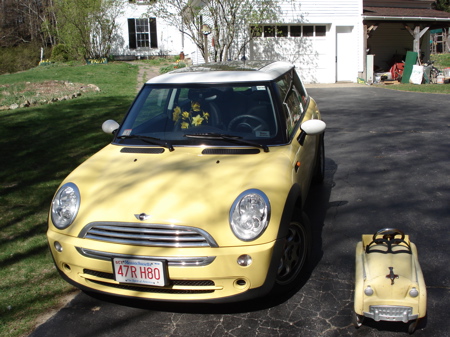 yellow Mini Cooper next to small yellow child's car
